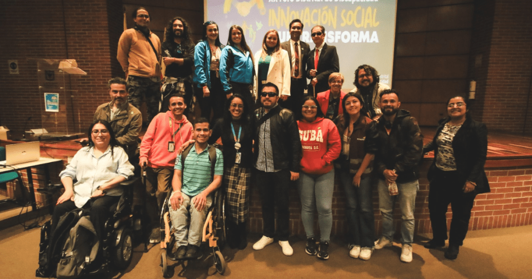 Imagen de ciudadanos en condición de discapacidad junto con funcionarios en el Foro Distrital de Discapacidad.