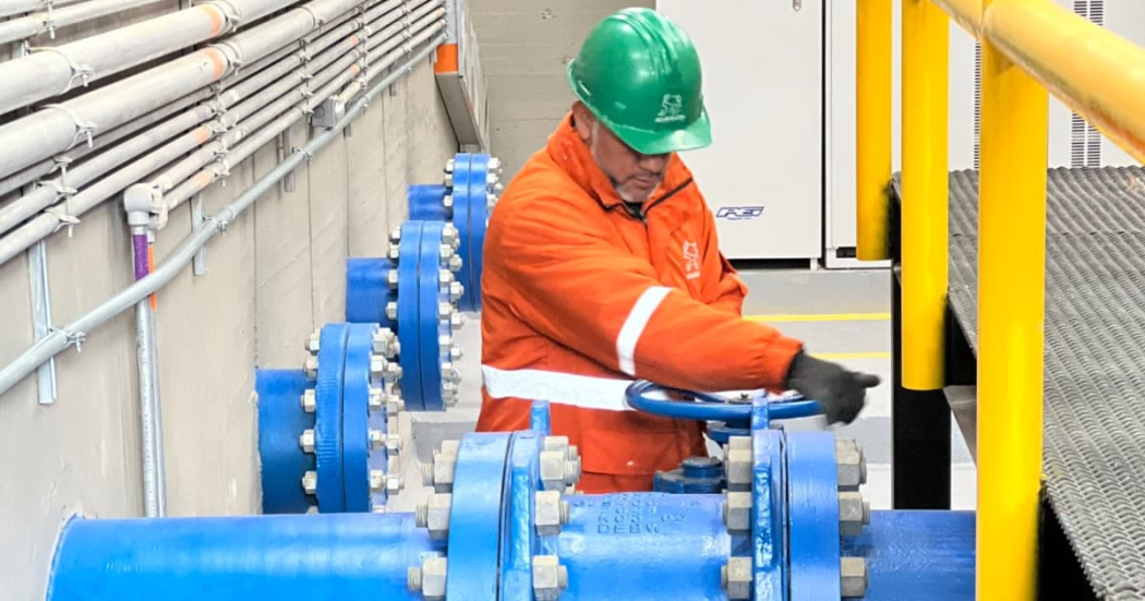 Imagen de técnico de la Empresa de Acueducto operando maquina identificada con imagen de la empresa