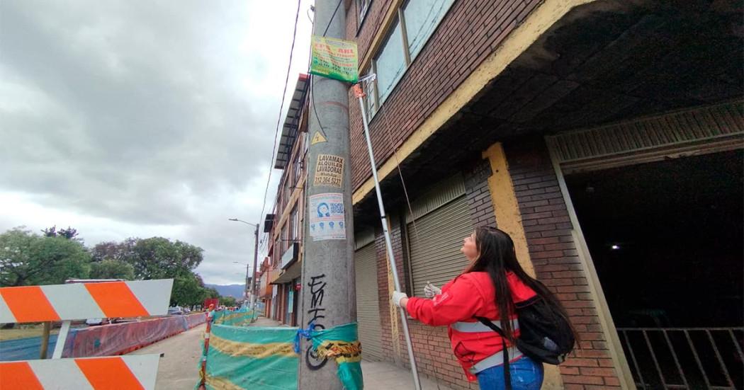 Imagen de una funcionaria pública retirando la contaminación visual.