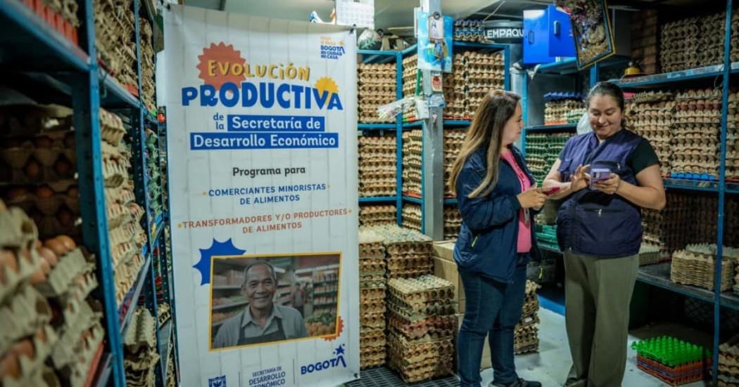 Una comerciante recibiendo en su negocio información sobre el programa 'Evolución Productiva'.