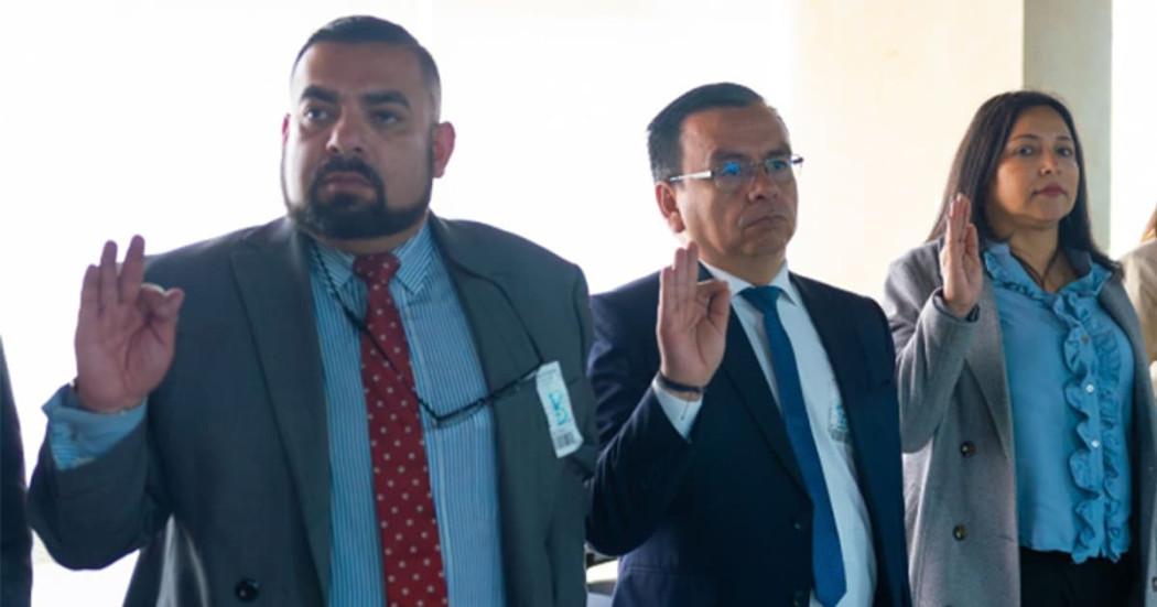 En la foto tres personas haciendo un juramento 