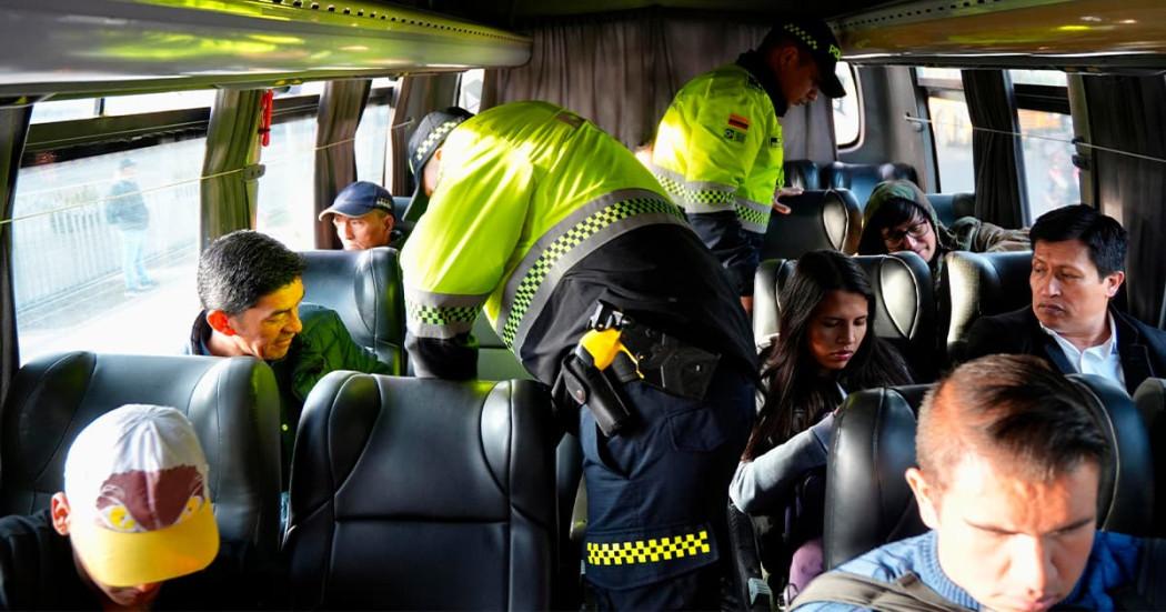 En la foto hay unos policías inspeccionando y requisando a los pasajeros de un bus intermunicipal 