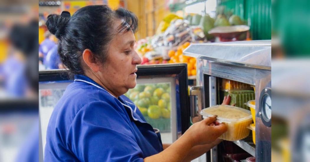Mujer en una de las Plazas Distritales de Mercado de Bogotá en proceso de aprovechamiento de alimentos.