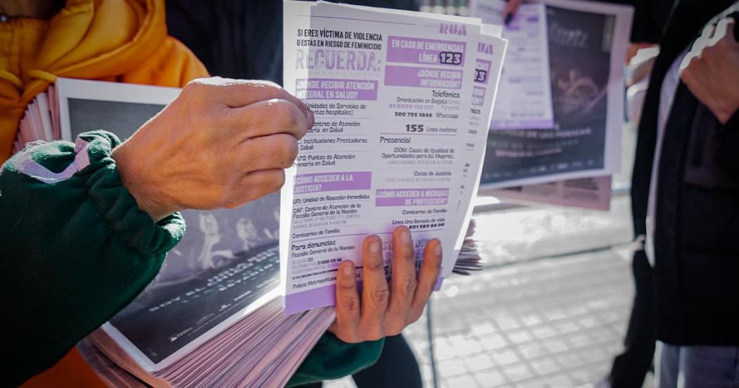 En la foto una señora mostrando y entregando un volante sobre la Ruta Única de Atención en las URI de Bogotá