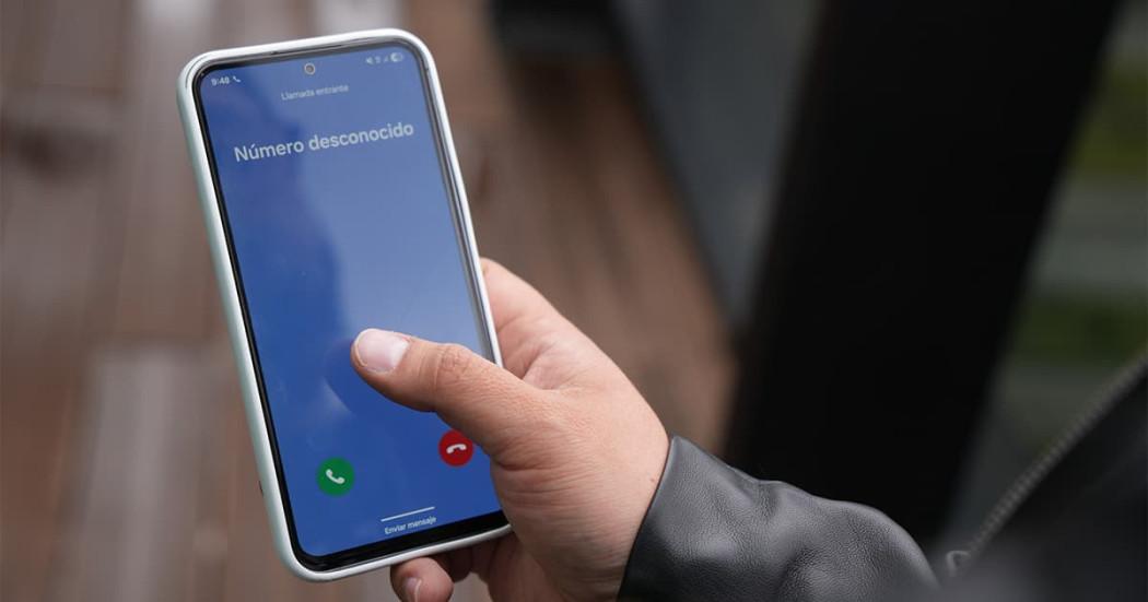 En la foto una persona mostrando el celular cuando está recibiendo una llamada extraña