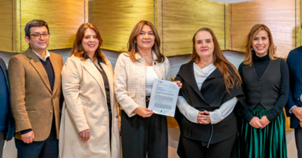 Imagen de varias personas con un documento y posando para la foto