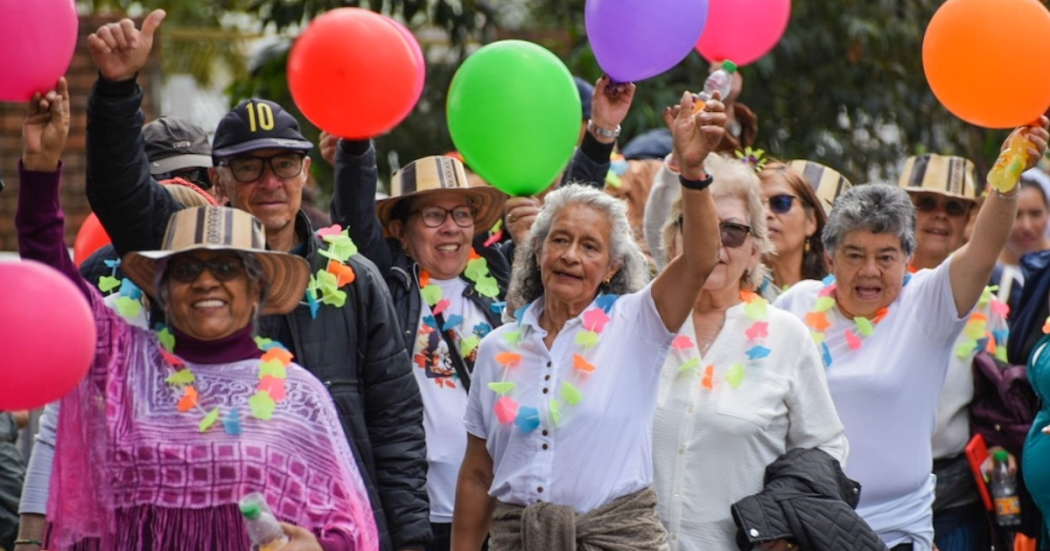 Imagen de personas mayores felices alzando unas bombas