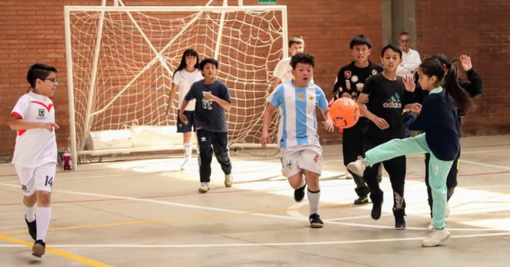 Niños y niñas jugando fútbol de salón