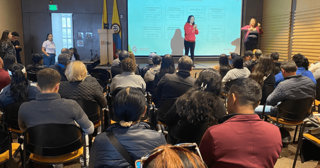 Foto de una mujer hablando en un auditorio 