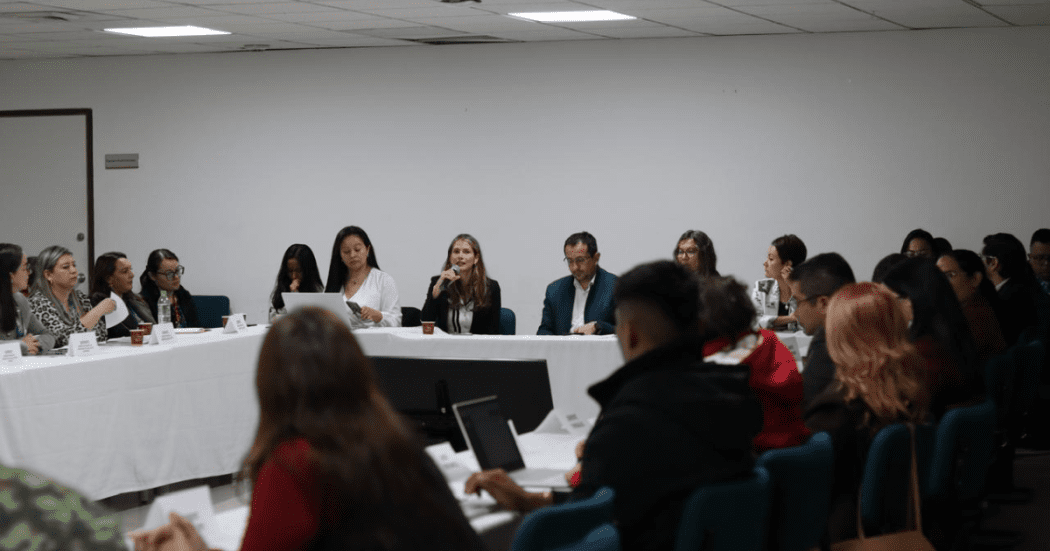 Foto de una mujer hablando en un auditorio sobre la vacunación en Bogotá
