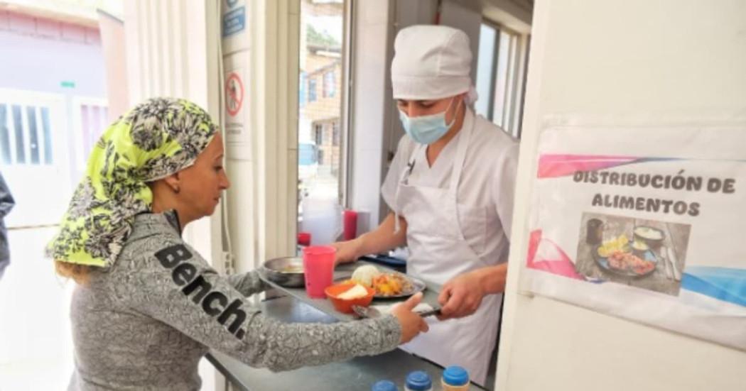 Una persona recibiendo alimentos en un comedor comunitario 