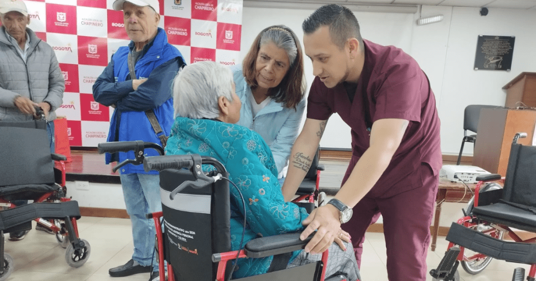 Foto de un operario atendiendo una mujer con discapacidad 