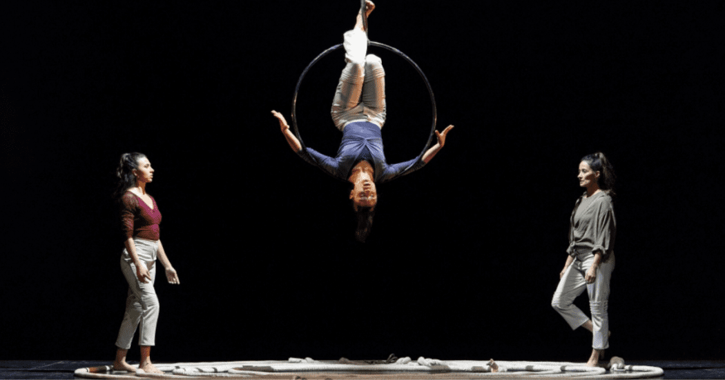 Imagen de un escenario donde pende un malabarista colgado en una circunferencia