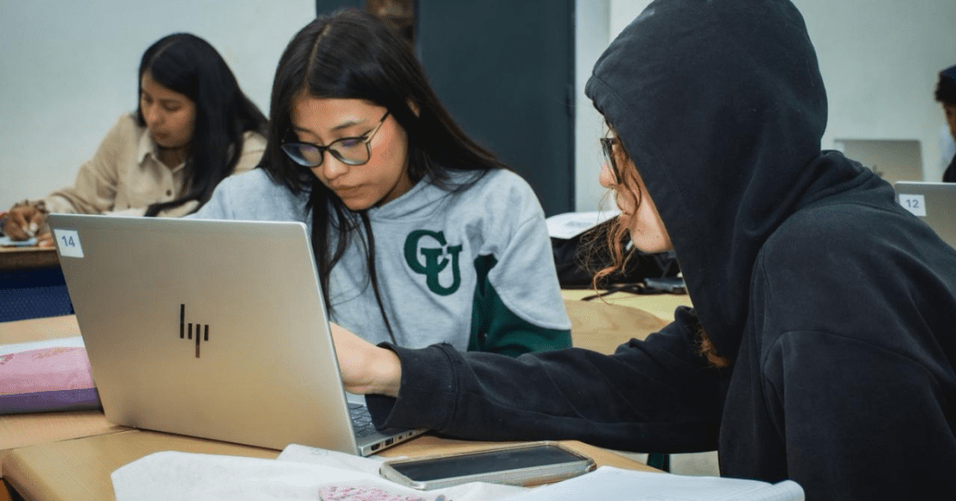 Foto de dos jovenes en un computador 