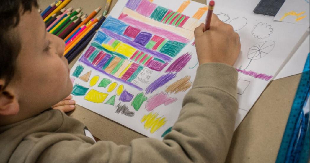 Imagen de niño dibujando sobre una hoja