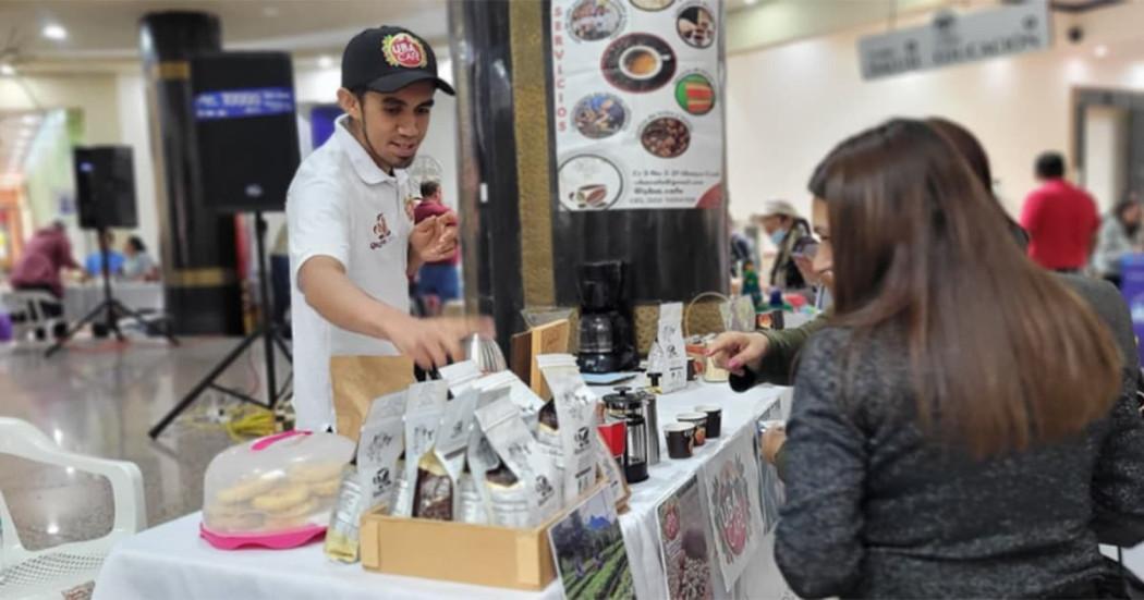 En la foto dos personas mirando y comprando los productos que se ofrecen en la feria