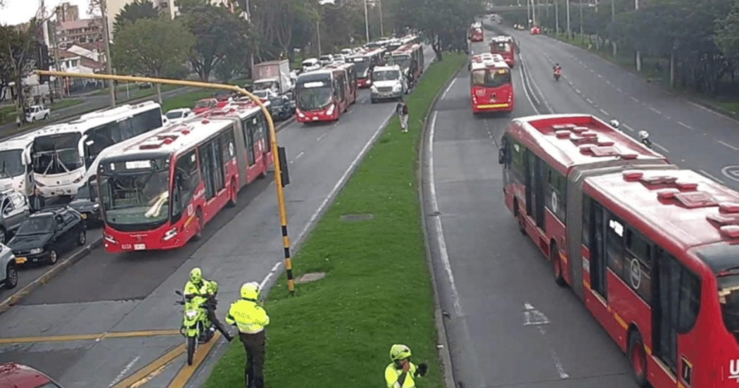 Imagen de una vía de Bogotá en la que se ven policías de tránsito, carros y buses de TransMilenio