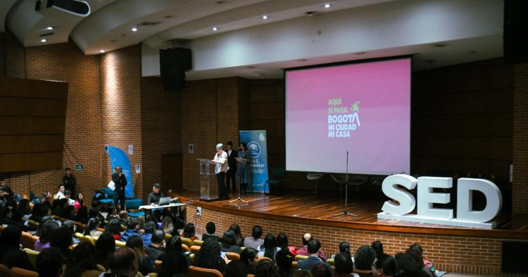 Foto de un auditorio que muestra personas sentadas en una conferencia