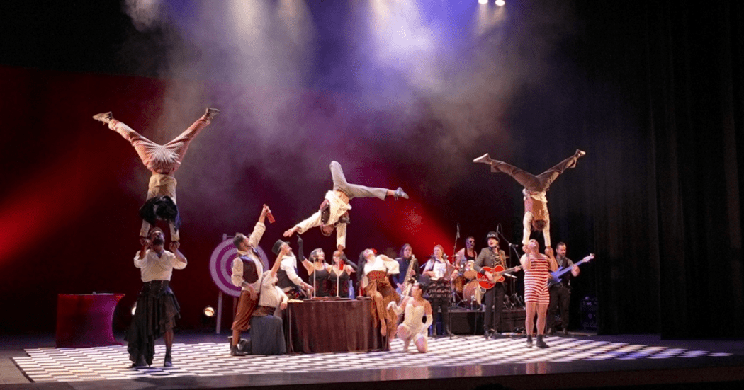 Imagen de la obra en el escenario donde se aprecian varios artistas haciendo sus malabares.