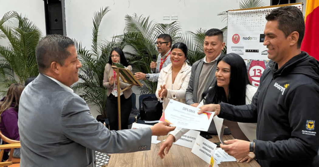 Imagen de un funcionario entregando un diploma a un comerciante