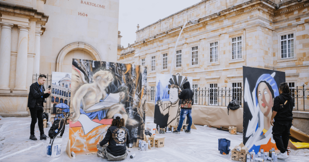 Imagen de varios artistas del gafiti pintando sus obras y de fondo la iglesia de San Francisco