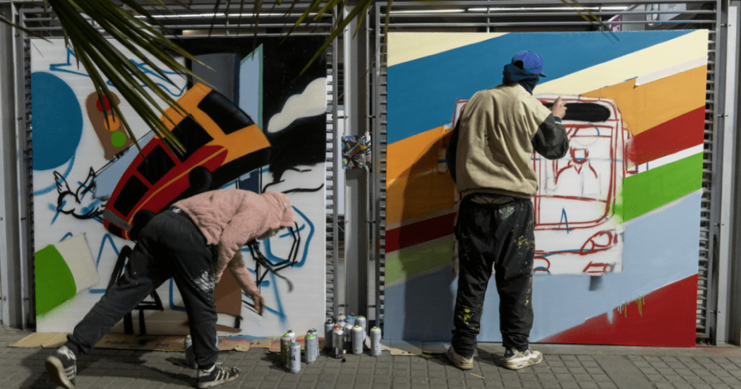 Imagen de dos artistas interviniendo una estación de TransMilenio