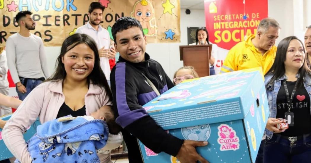 Una pareja de jóvenes sonriendo recibiendo su ‘Cuna con Amor