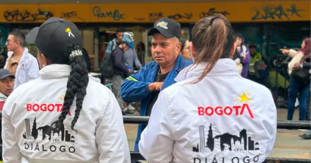 En la foto dos gestores de diálogo social hablando con una persona 