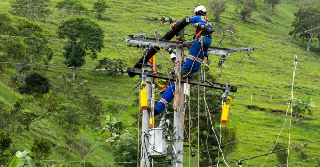 Foto que muestra trabajadores de Enel Colombia realizando sus labores en un poste de luz.