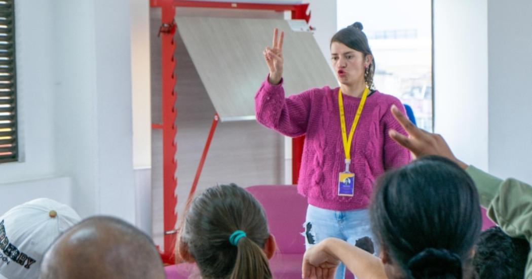 Foto que muestra una mujer ejecutando actividades con lengua de señas en las bibliotecas.