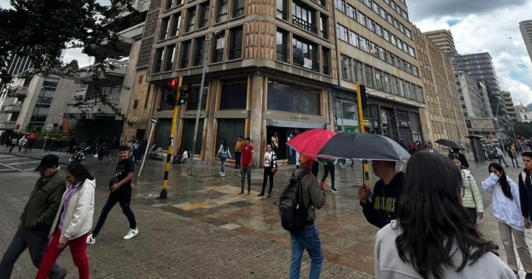 Foto de una calle de Bogotá en un día de lluvia con personas usando sombirilla