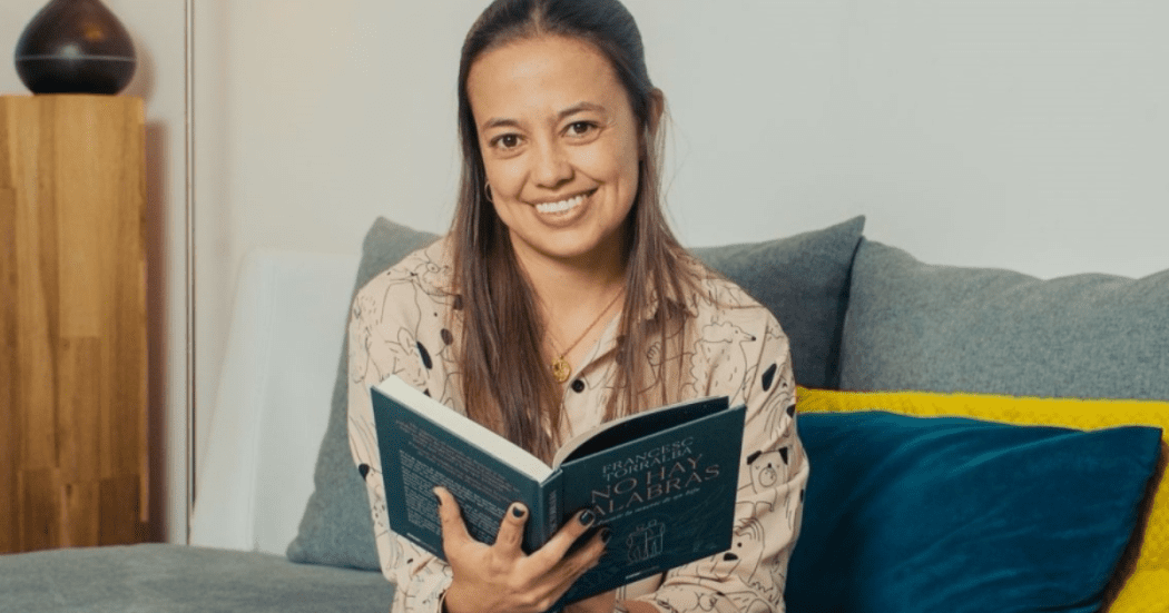 Imagen de mujer joven sentada con un libro en la mano