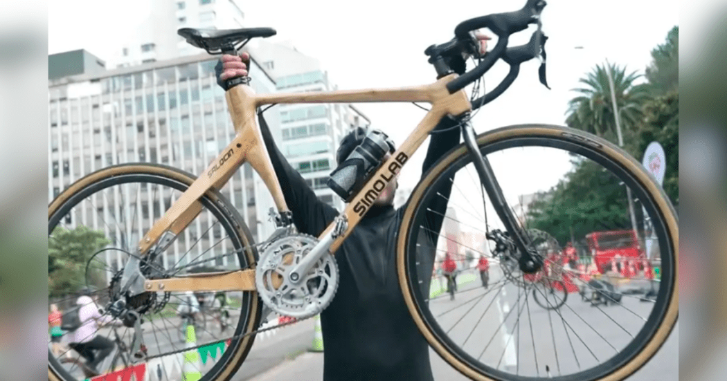 Imagen de un hombre que toma en sus manos una bicicleta.