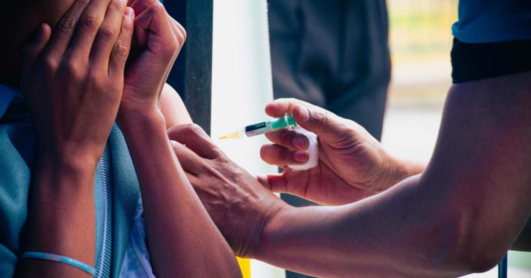 Foto que muestra una persona que le están colocando una vacuna en su brazo