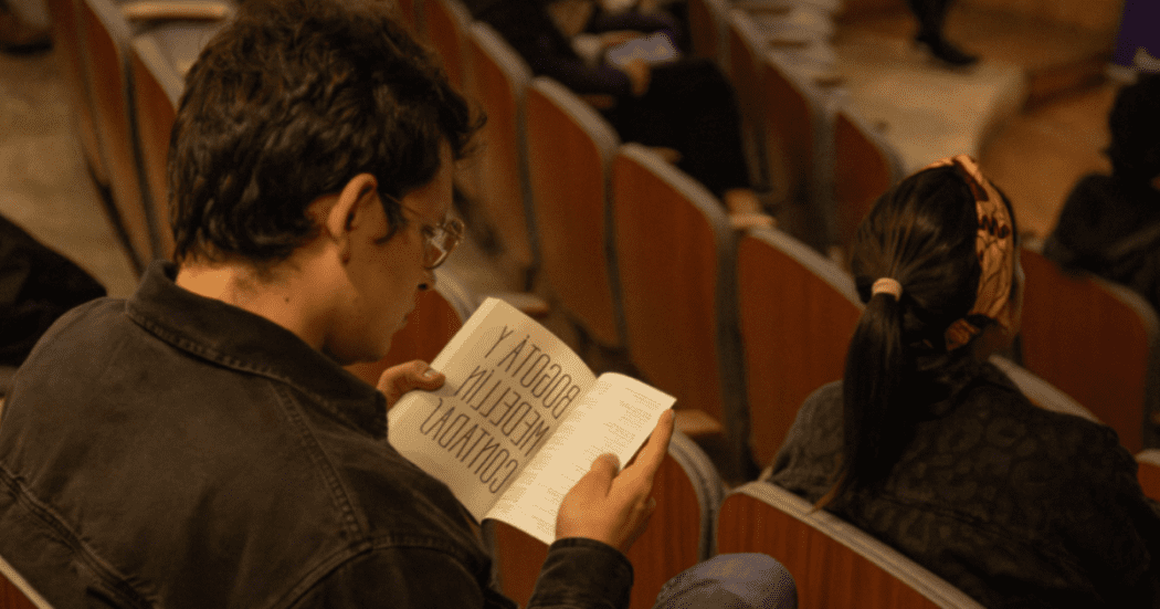 Imagen de un hombre joven sentado leyendo un libro