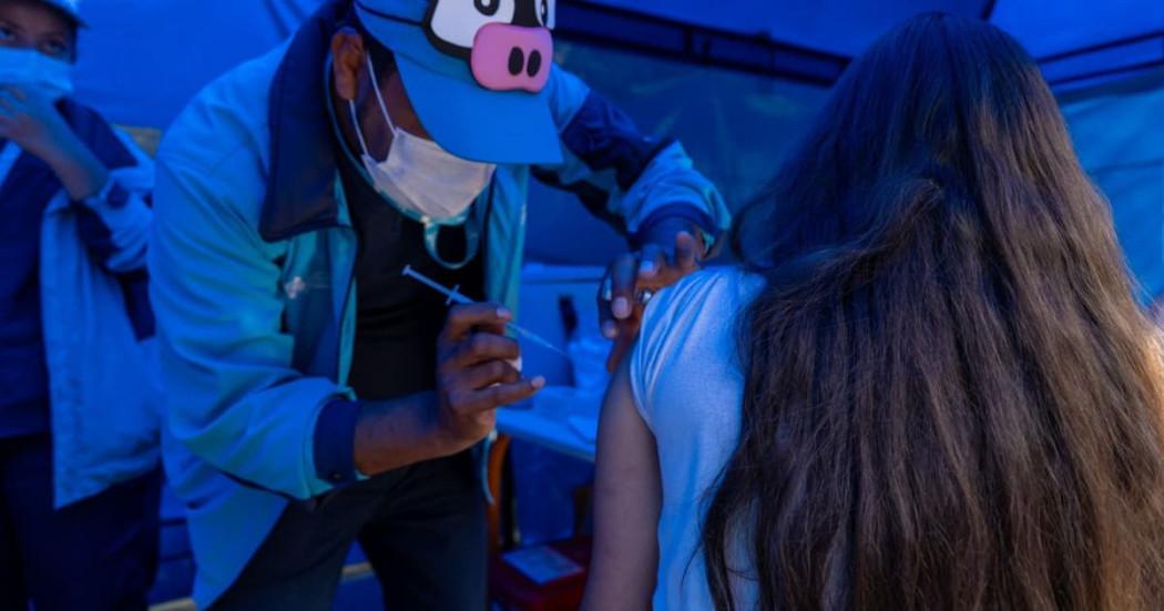 Foto de una enfermera colocando una vacuna en el hombro de una persona