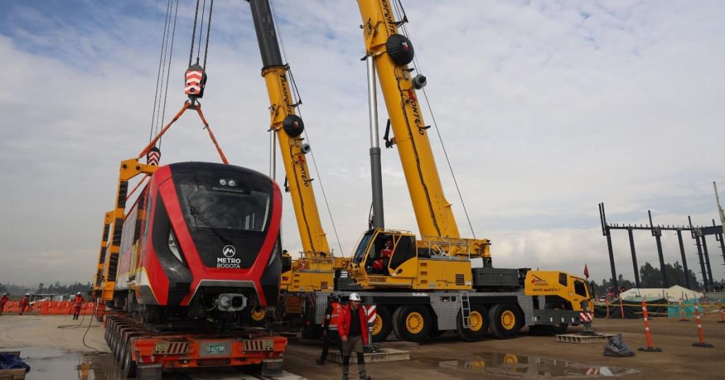 Foto de una grua telescópica descargando uno de los vagones del tercer tren de la Línea 1 del Metro.