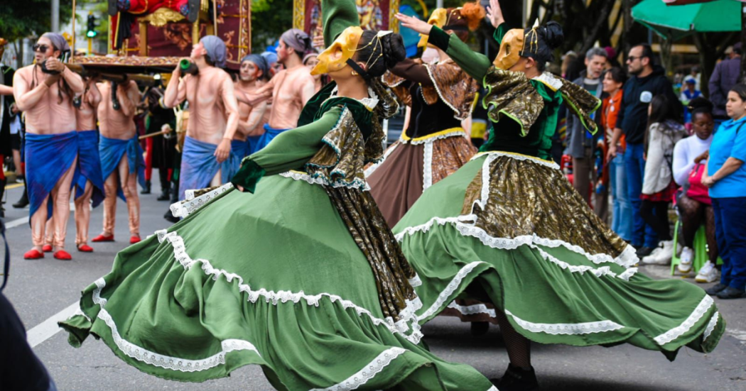 Foto de colorido desfile cultural en una calle de Bogotá.