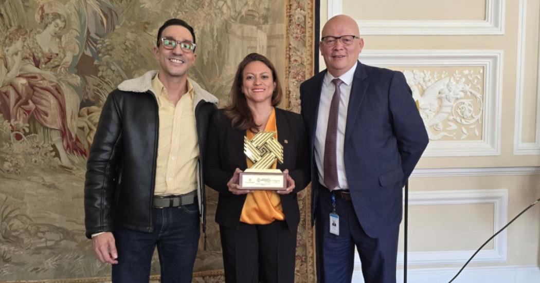 Foto que muestra a tres personas sonriendo 