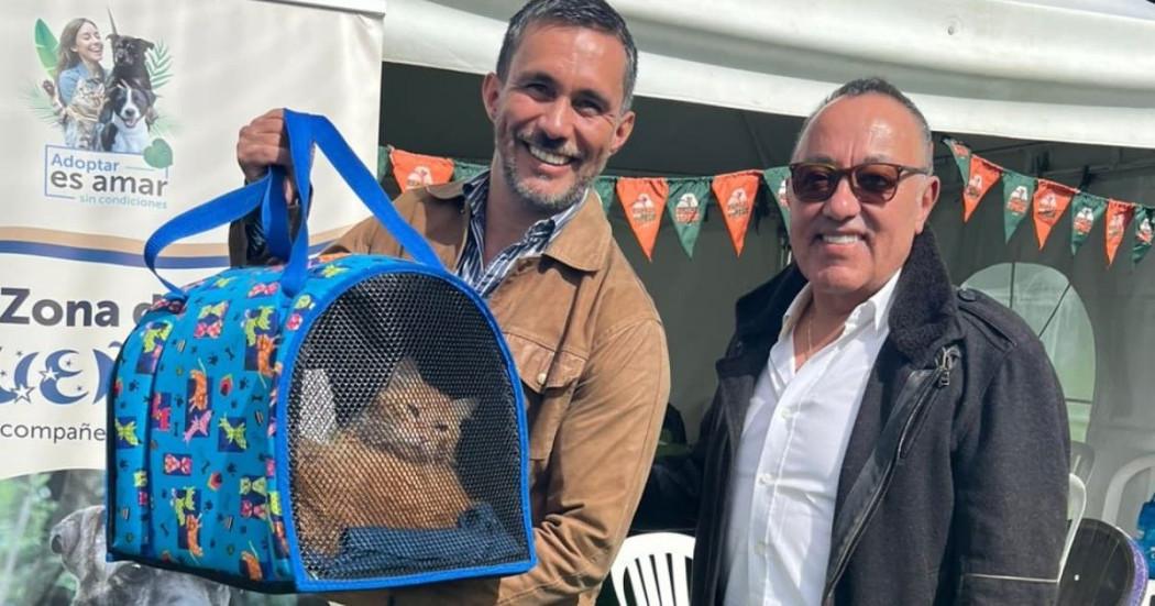 Foto de dos personas con un gato adoptado