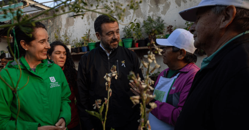 Foto del alcalde Galán hablando con una señora en un jardín