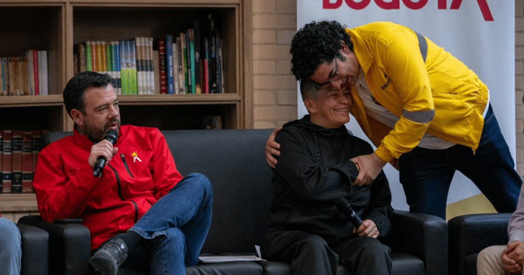 Imagen del alcalde Galán junto a un exhabitante de calle que es abrazado por el secretario de Integración Social