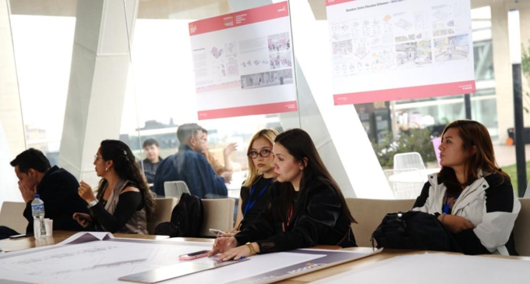Foto que muestra personas sentadas al rededor de una mesa