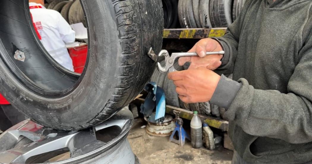En la foto un señor despinchando una llanta