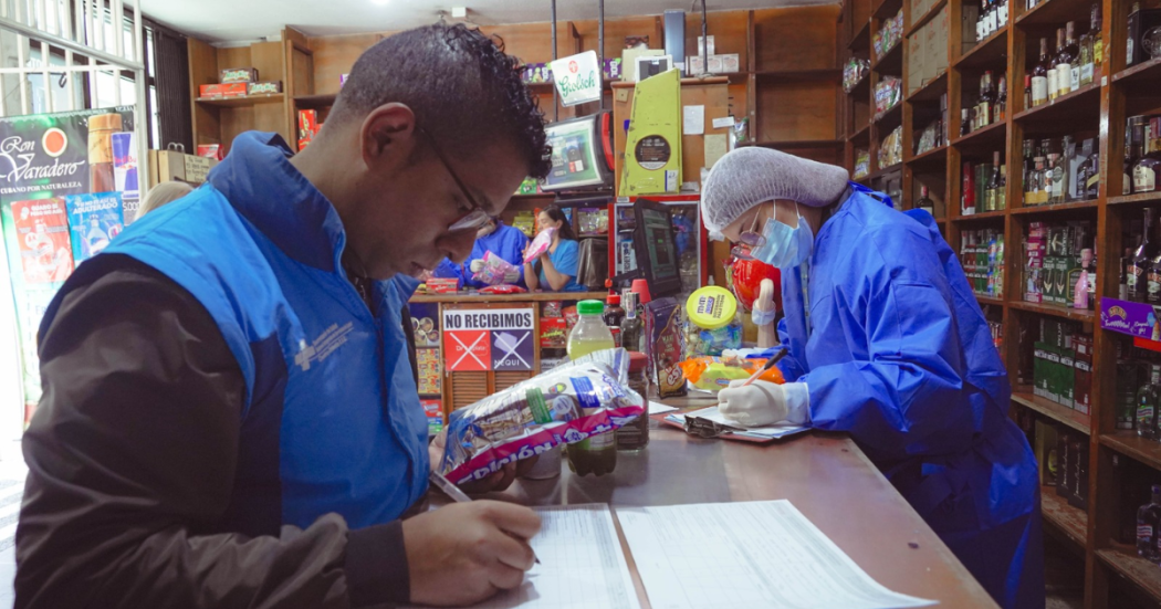 Foto de funcionarios de salud inspeccionan productos en un establecimiento para verificar su calidad y garantizar la seguridad alimentaria durante el fin de año.