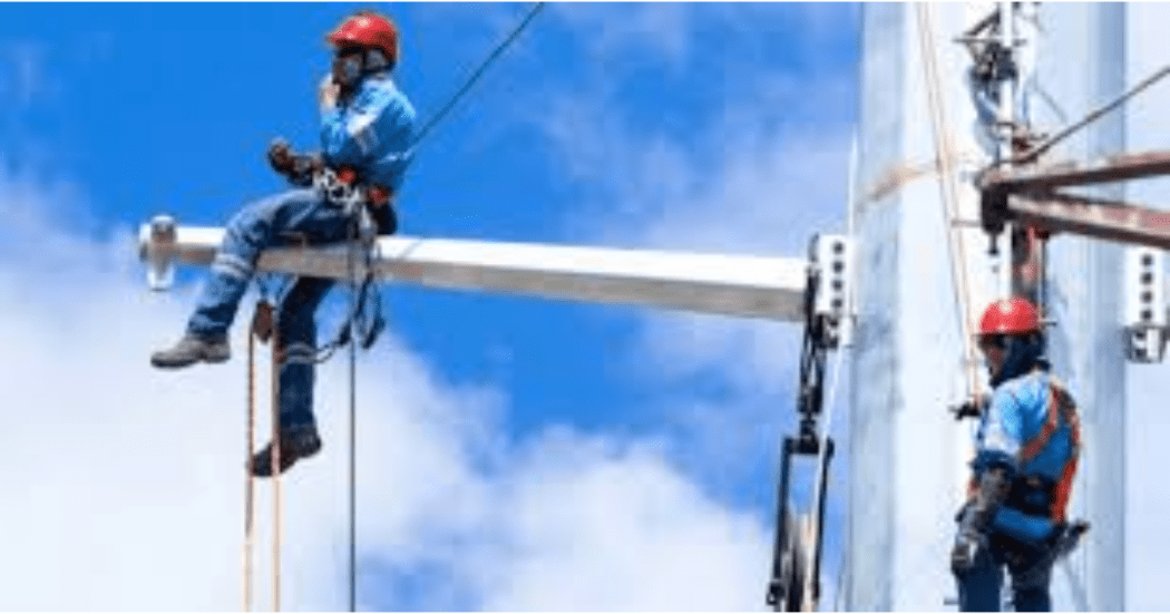 Imagen de tecnicos de Enel que revisan los cables de energía de un poste.