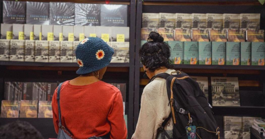 Imagen de dos mujeres observando un stand de libros del IDPC