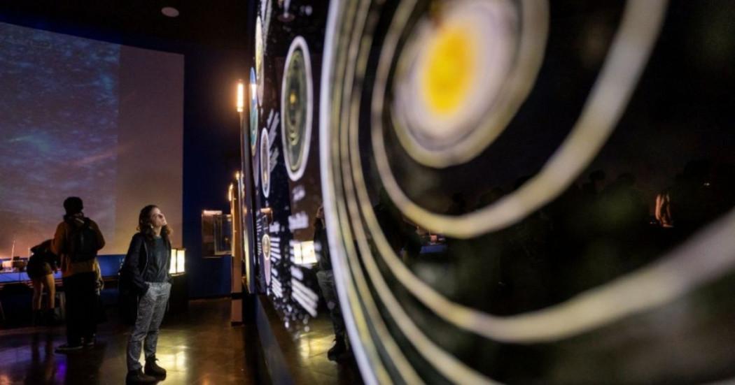 Imagen de personas observando exposición Máquinas para atrapar cometas y meteoritos