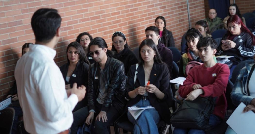 Foto que muestra personas sentadas en un salón