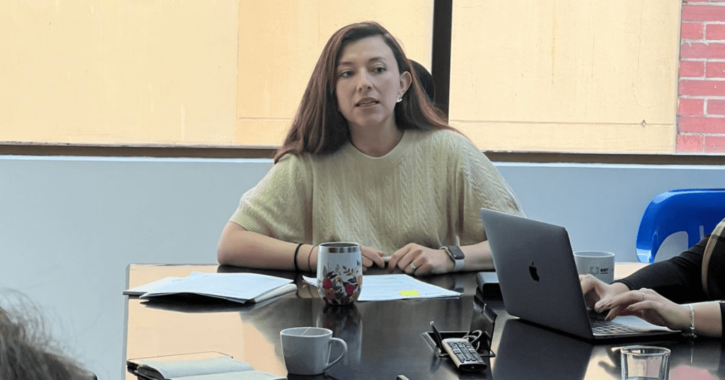 Foto de una mujer participando activamente en una reunión de trabajo.